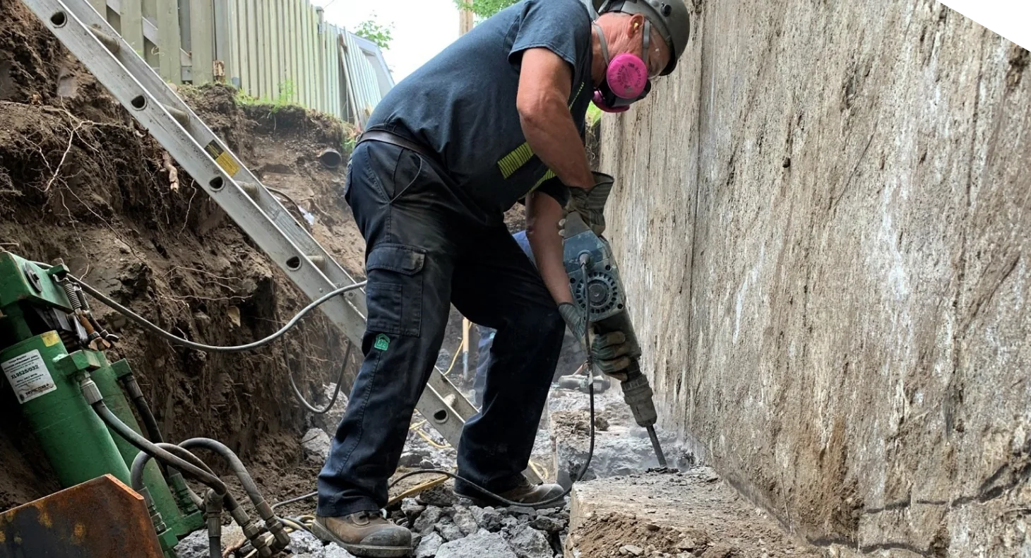 Travailleurs reconstruisant un mur de fondation